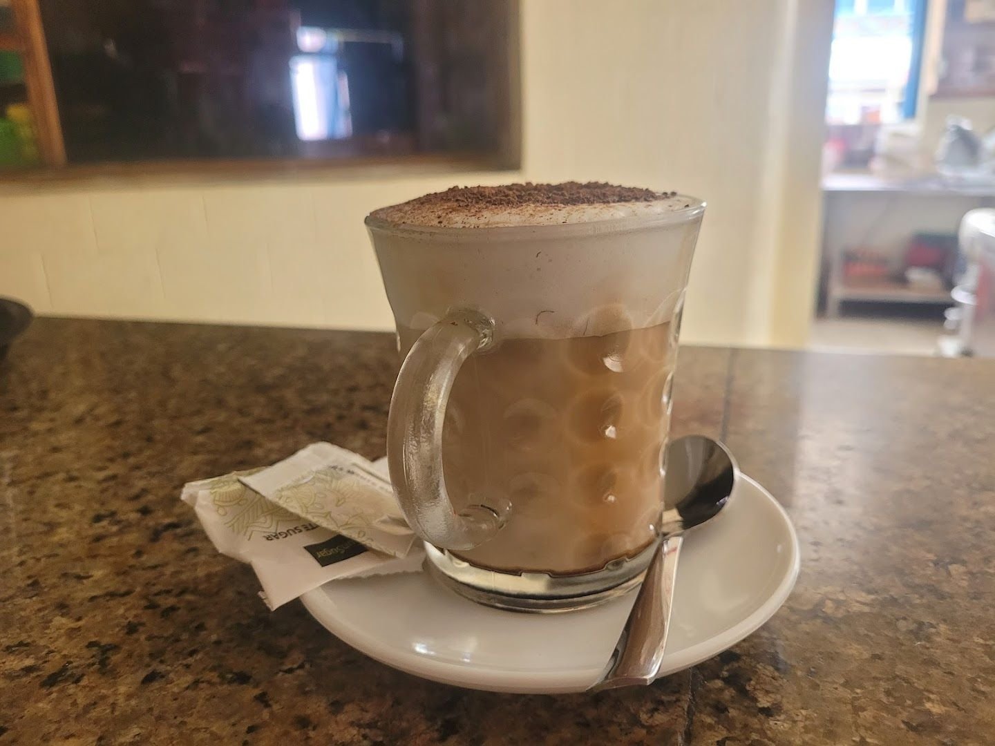 A cappuccino with milk foam and a dusting of cocoa, served at the bar