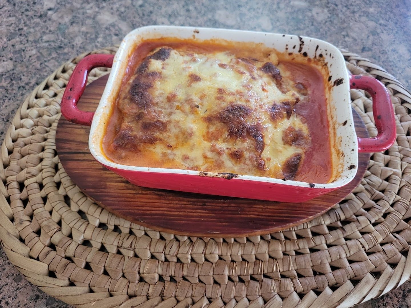 An individual baked lasagna with a browned, bubbling cheese top